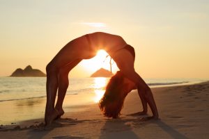 a confident girl doing yoga on the beach after full bikini waxing in Tallahassee
