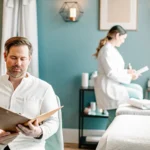 Professional esthetician providing a male waxing service in a clean, modern treatment room