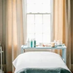 Professional esthetician preparing a clean treatment room for a waxing appointment